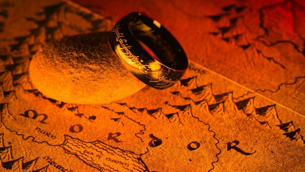 A picture of the one ring resting on top of a map of the middle earth.