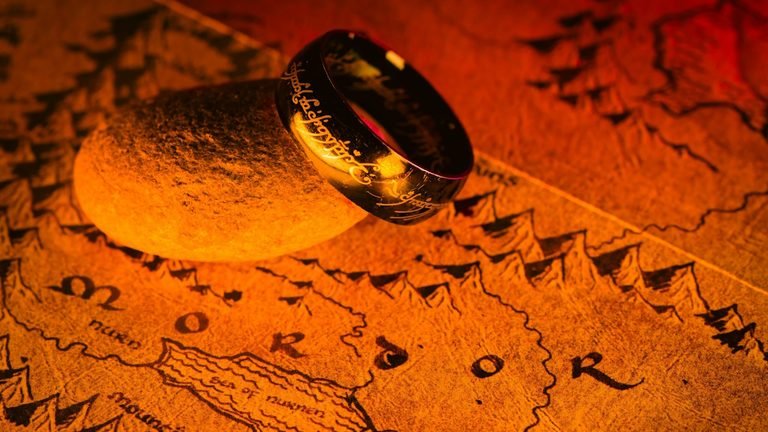 A picture of the one ring resting on top of a map of the middle earth.