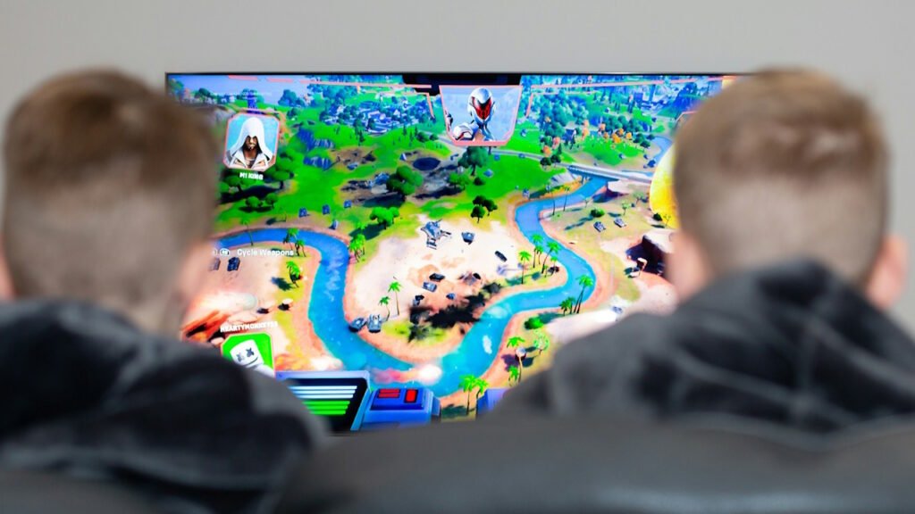 Two kids playing games on a TV.