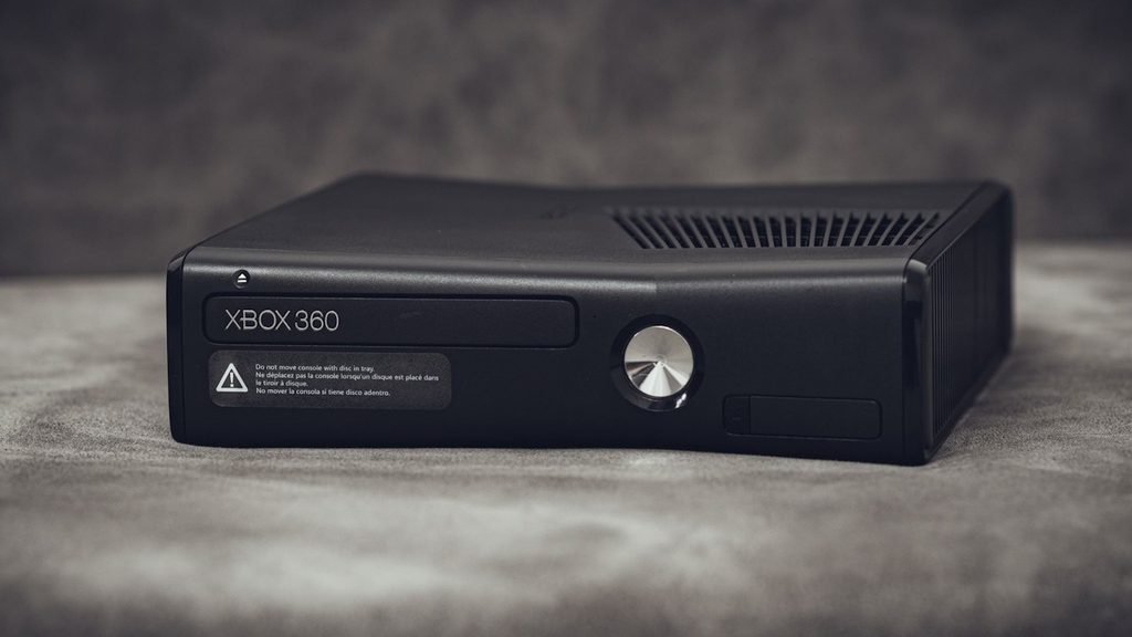 An Xbox 360 console lying on a desk.