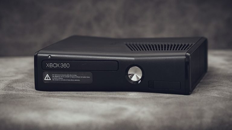 An Xbox 360 console lying on a desk.